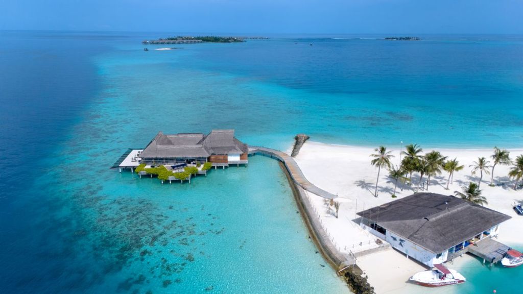 Aerial tropical island resort surrounded by turquoise water.