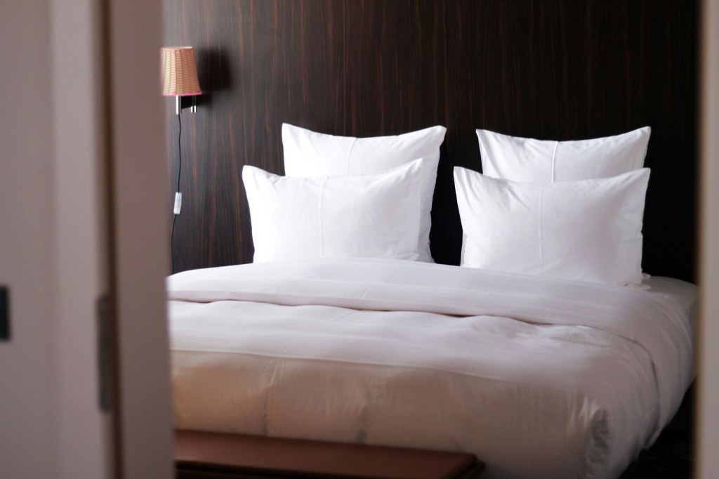 Close-up of a white pillow on crisp white bed linen
